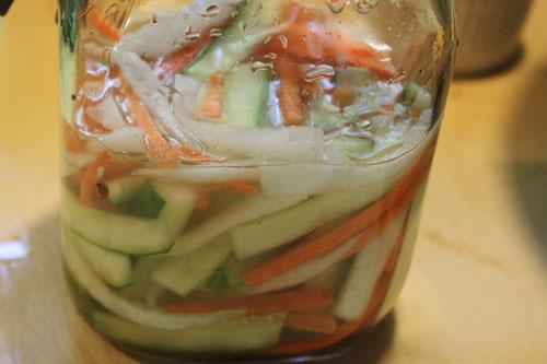 Cho rau củ cùng nước chua ngọt vào lọ thủy tinh để khoảng nửa ngày là ăn được.
