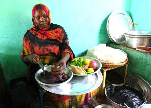 Một phụ nữ ở Al Jazeera, Sudan chuẩn bị một món ăn với gan lạc đà. Từ năm 1996 đến năm 2002, Sudan ước tính đã sản xuất giữa 72.000 và 81.000 tấn thịt lạc đà mỗi năm.