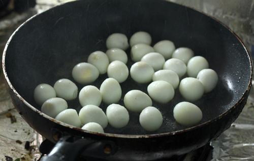 Sau khi luộc và bóc vỏ, bạn nên rán trứng cút để món ăn thêm thơm ngon.