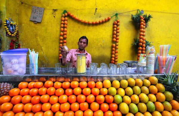 Du khách khi đến Ấn Độ, đặc biệt là Kolkata sẽ thấy những cửa hàng bày bán trái cây tươi và nướp ép rất được ưa chuộng. Người mua sẽ tự tay chọn quả và nhân viên bán hàng sẽ pha chế ngay trước mặt du khách. Dù là cửa hàng vỉa hè nhưng được trang trí rất thu hút và bắt mắt. Ảnh: Mahfuzul Hasan Bhuiyan